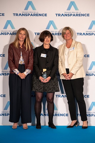 Imagem de três mulheres reunidas com um fundo temático com o logo do Grands Prix de la Transparence